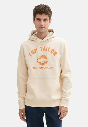 Beige hoodie featuring hood and front pocket, with orange text reading "TOM TAILOR PREMIUM QUALITY" and a round logo detail. Smooth texture.