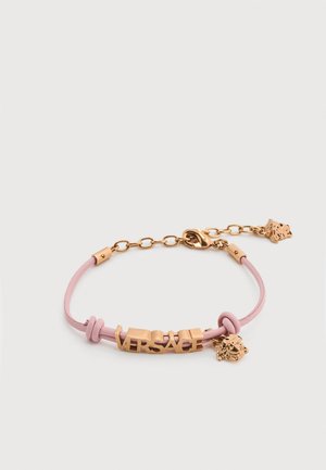 Pink leather bracelet with gold "VERSACE" letters and Medusa head charms, adjustable gold chain clasp on a white background.
