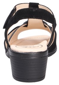 Sandalo in suede nero con tacco basso, caratterizzato da un design con retro aperto, soletta imbottita e cinturini alla caviglia regolabili. Suola testurizzata per aderenza.