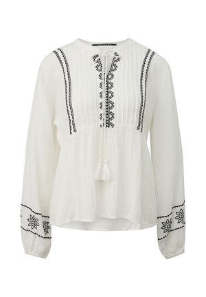 Camicia bianca a maniche lunghe con motivi geometrici neri ricamati, davanti plissettata e laccetti con nappine al collo e ai polsi.
