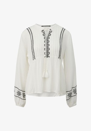 Camicia bianca a maniche lunghe con motivi geometrici neri ricamati, davanti plissettata e laccetti con nappine al collo e ai polsi.