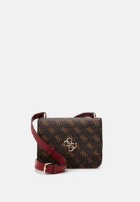 Brown patterned crossbody bag with gold monogram logo and adjustable burgundy leather strap on white background.