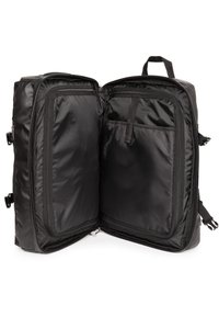 Musta matkalaukku suorakaiteen muotoinen, kaksivetoketjullista osastoa, sisätaskuja ja sileä, kestävä nailonpinta.