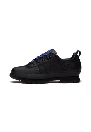 Black low-top hiking shoe with textured leather, blue laces, metal eyelets, padded collar, and rugged sole on a white background.