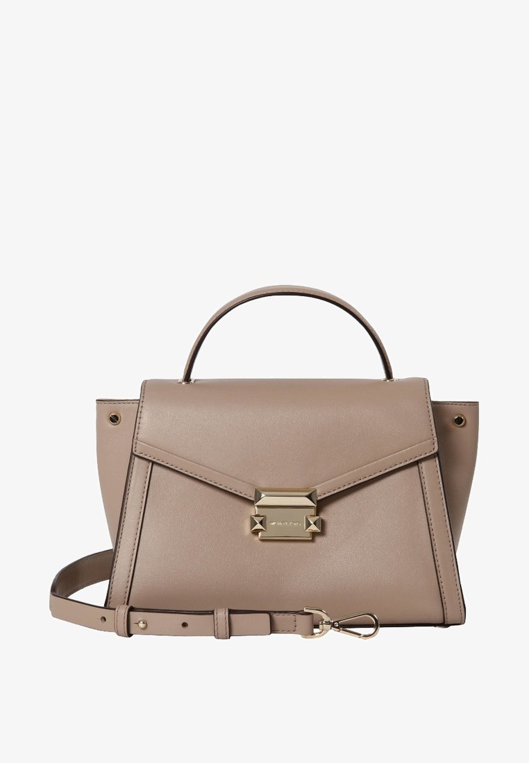 Sac à main en cuir taupe avec poignée supérieure, fermoir doré et bandoulière amovible posé devant sur fond blanc.