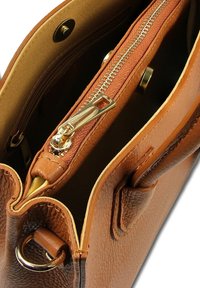 Bruine leren handtas met gouden hardware, voorzien van een ritssluiting en een textuur oppervlak. De binnenkant heeft een gladde voering en meerdere compartimenten.