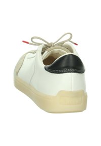 Weiße Ledersneaker mit beigen Wildlederakzenten, einer schwarzen Lederferse und einer hellbeigen Gummisohle. Mit beigen Schnürsenkeln und einem roten Etikett.