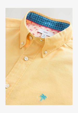 Gul skjorte med knapper og blå palmebroderi, udstyret med en kontrastfarvet krave indeni i blå og pink mønster samt to forreste knapper.