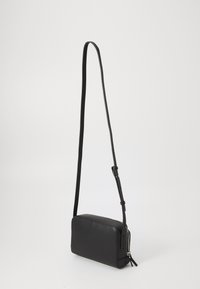 Black leather crossbody bag with a rectangular shape, long adjustable strap, and a zipper closure. Smooth texture with minimal hardware.