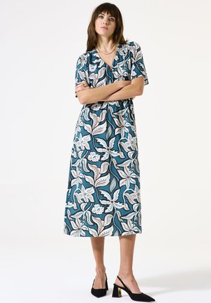 Cyan bloemen midi-jurk met korte mouwen, voorzien van een cinched taille, ingewikkelde witte en roze patronen, en instap zwarte pumps met gouden accenten.