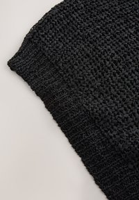 Tessuto nero intrecciato con una superficie testurizzata, caratterizzato da un design a treccia larga. Il bordo presenta una transizione fluida verso un tessuto più stretto.