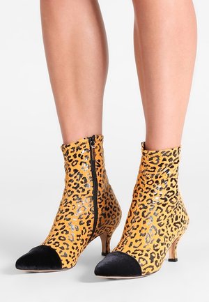 Leopardprint enkellaarsjes met een glanzend oppervlak, zwart fluwelen neus, en een zijrits, met een kittenheel.