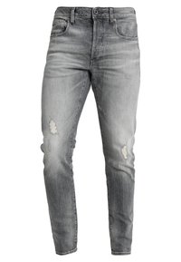 Jeans de denim gris con ajuste slim, que presentan áreas desgastadas y un acabado desvanecido. Diseño clásico de cinco bolsillos con cierre de botón.