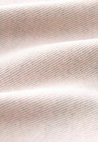 Tissu rose clair avec une texture fine à côtes diagonales, présentant de subtiles mouchetures plus foncées. Surface douce et lisse.