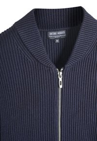 Mornarska rebrasta kardigan izrađena od mješavine tehno vune, sa zatvaranjem na zatvarač i standardnim dizajnom ovratnika. Veličina oznaka: M.