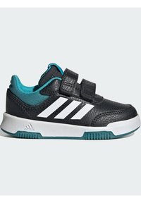 Scarpe da ginnastica nere con tre strisce bianche, dotate di strap in velcro, una tomaia in pelle testurizzata, un rivestimento interno color teal e una suola bianca.