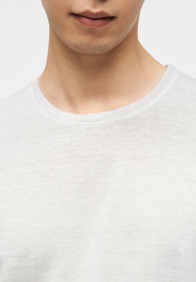 Ανοιχτό γκρι t-shirt με στρογγυλή λαιμόκοψη, κατασκευασμένο από απαλό, ελαφρώς υφασμένο ύφασμα. Διαθέτει λεία λαιμόκοψη και άνετη εφαρμογή.