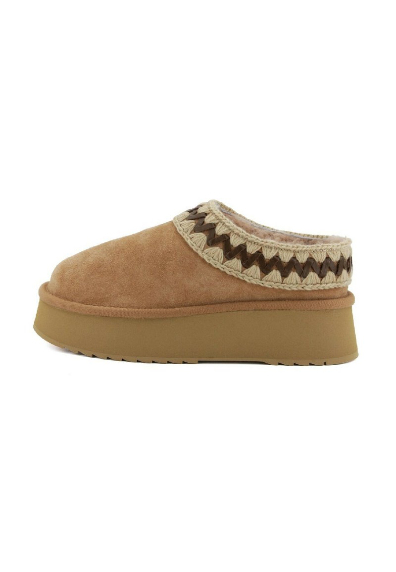 Scarpe slip-on in suede marrone con un colletto intrecciato in crema e marrone scuro dalla texture, dotate di una suola piatta spessa e una parte inferiore in gomma.