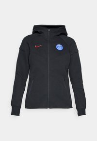 Svart hettejakke med sportsdesign, med rødt Nike-logo og blå Paris Saint-Germain-emblem, laget av teksturert stoff med sidelommer.