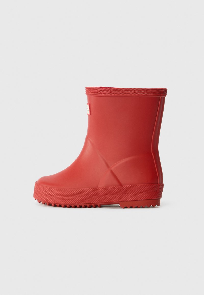 Bota de chuva vermelha em borracha com textura lisa, bico arredondado e sola ranhurada. Apresenta uma altura curta e uma borda reforçada na parte superior.