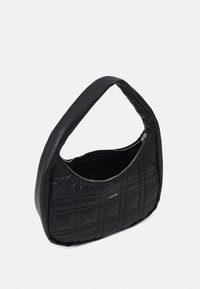 Sac à main synthétique noir matelassé avec une anse courbée et fermeture à glissière. Il présente une texture lisse et un logo subtil sur le côté.