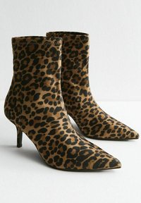 Botas de tobillo de estampado de leopardo en tejido suave, con punteras afiladas, tacones de aguja negros de 5 cm y un diseño ajustado.