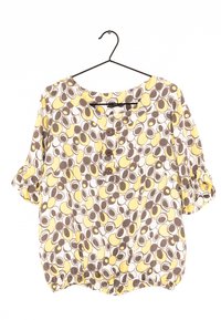 Blouse à manches courtes avec un col rond, présentant un motif circulaire marron, jaune et blanc, et trois boutons en bois à l'avant.