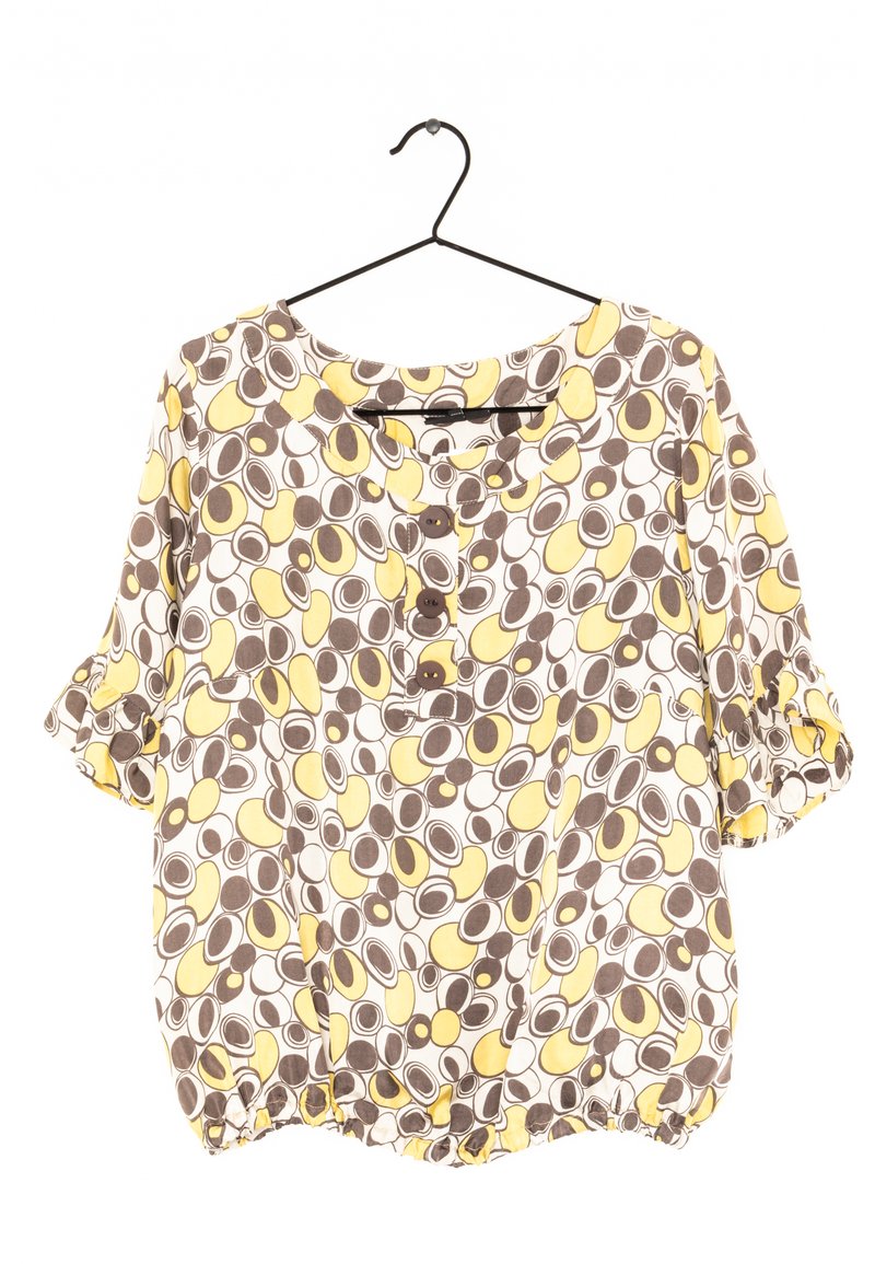 Kurzarmbluse mit Rundhalsausschnitt, mit einem braunen, gelben und weißen kreisförmigen Muster sowie drei Holzknöpfen an der Vorderseite.