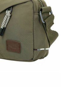 Grøn nylon taske med struktureret overflade, med et brunt lædermærke, grå, hvid og brune striber samt en side rem fastgørelse.