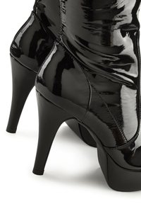 Black patent leather high-heeled boot with a smooth, shiny finish, featuring a pointed toe and a contoured ankle design.