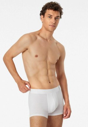White cotton boxer briefs with a smooth texture, elastic waistband, and a fitted design, displayed on a male model with a neutral background.