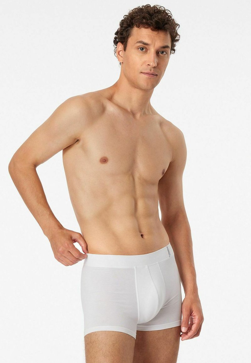 White cotton boxer briefs with a smooth texture, elastic waistband, and a fitted design, displayed on a male model with a neutral background.