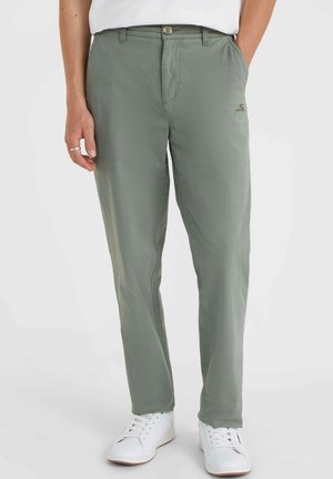 Lysgrønne chinos med normal pasform, glat stof og diskret logo-detalje, parret med hvide sneakers.