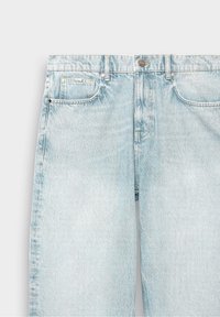 Jean en denim bleu clair délavé, visible de la taille au milieu des cuisses, doté de poches avant, de passants de ceinture et d'une fermeture à bouton.