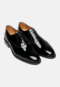 Scarpe da sera in vernice nera con una finitura liscia e lucida, punta affusolata e design con lacci. Presentano una fodera interna di colore chiaro.