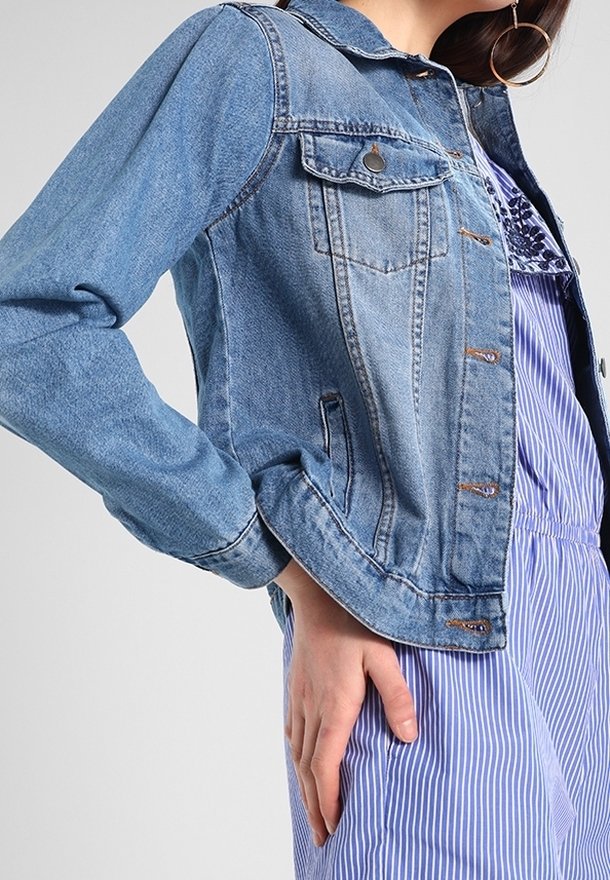 Jeansjacka med ljusblå tvätt, knappstängning framtill, bröstfickor och en klassisk krage. Långärmad med manschettdetalj.