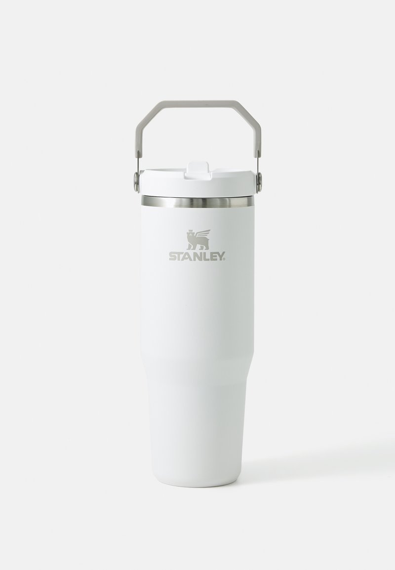 Mug de voyage en acier inoxydable blanc avec un corps effilé, un bord de couvercle argenté et une poignée grise. Présente un logo gravé à l'avant.