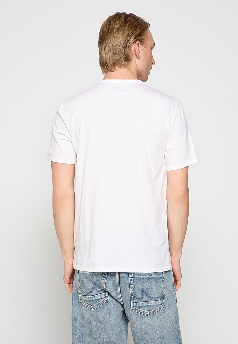 Weißes Baumwoll-T-Shirt mit kurzen Ärmeln, Rundhalsausschnitt und lockerer Passform, kombiniert mit hellblauen Jeans, von hinten betrachtet.