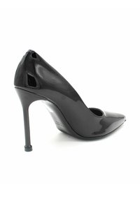 Scarpa con tacco alto in vernice nera, con punta affusolata, accenti laterali aperti e un sottile tacco a stiletto. Texture liscia e lucida.
