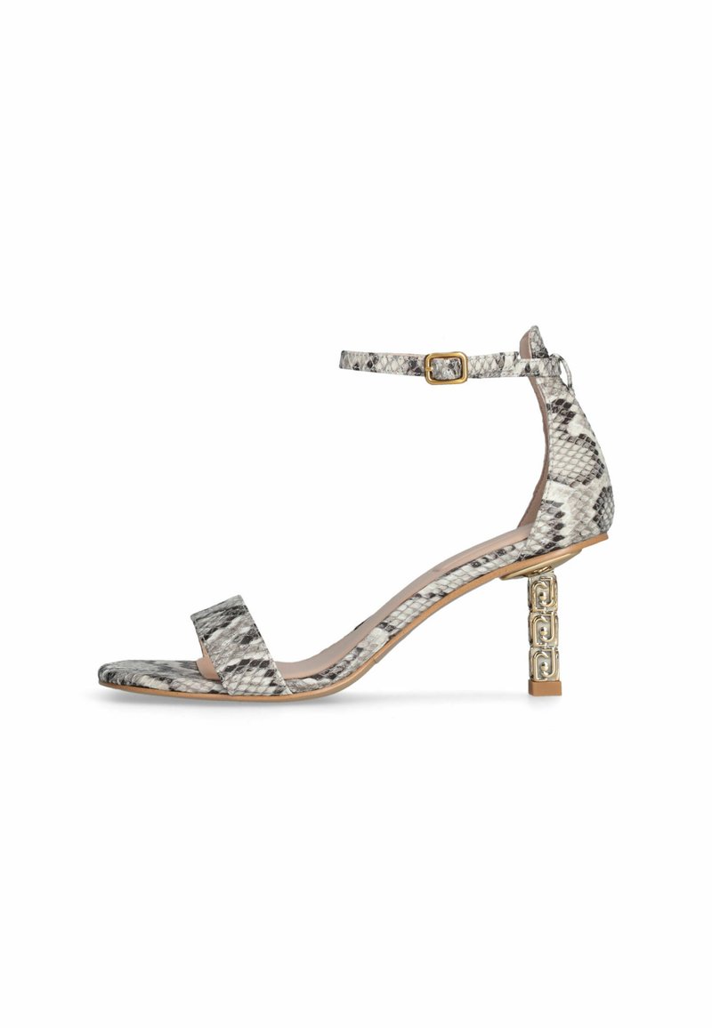 Sandali con tacco in stampa pitone grigia e bianca. Cinturino alla caviglia regolabile con fibbia dorata. Il tacco a blocco testurizzato presenta accenti geometrici.