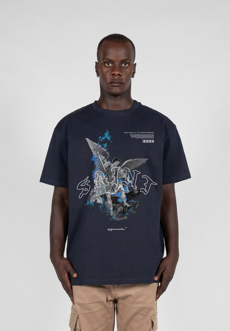 Marineblå grafisk t-shirt med et detaljeret print af en engel og en figur, med ordet "SAINT" i hvide stiliserede bogstaver. Lavet af bomuldsmateriale.