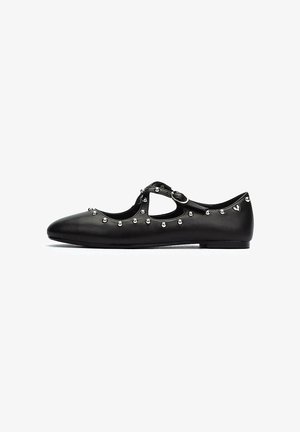 Ballerines en cuir noir avec bout rond, sangle à boucle et clous décoratifs en argent le long des côtés. Semelle plate, design minimaliste.