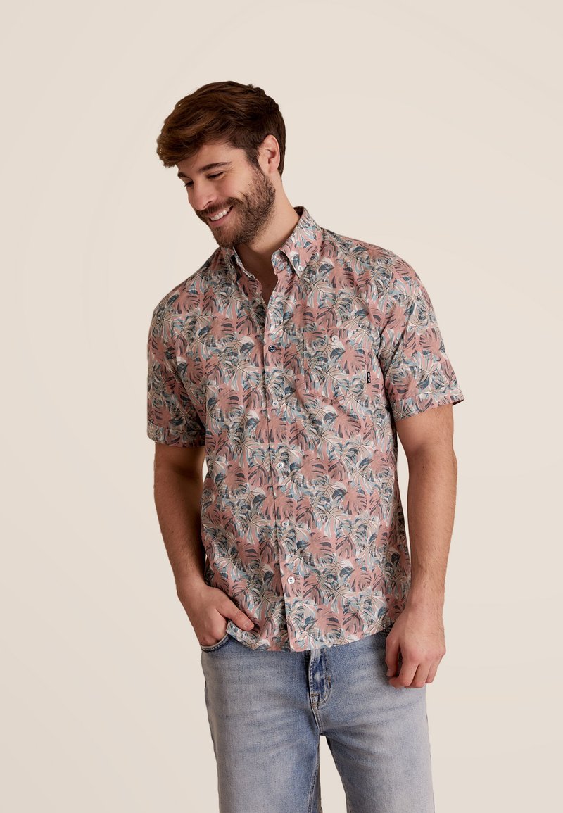 Korte mouwen shirt in roze met een blauw en groen palmenbladpatroon. Beschikt over een knoopsluiting en een enkele borstzak. Casual fit.