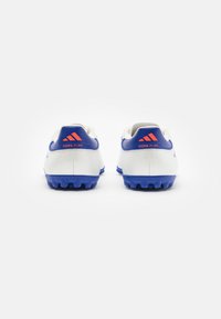 Scarpe da calcio bianche con accenti blu e branding arancione "Copa Pure". Presentano un tallone testurizzato e tacchetti modellati per una migliore trazione.