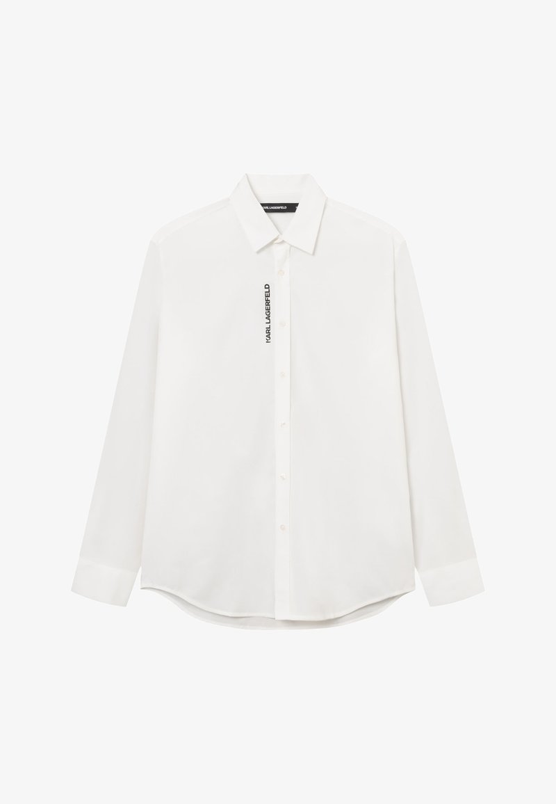 Biała koszula z długim rękawem zapinana na guziki, z ostrym kołnierzykiem i pionowym napisem „KARL LAGERFELD” obok guzików po lewej stronie.