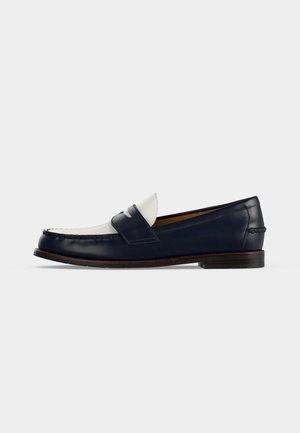 Chaussure mocassin homme en cuir bleu marine et blanc avec un petit talon en bois et un détail classique de bride penny.