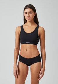 Zwarte katoenen sport-bh en bijpassende boyshorts met een ronde hals en elastische band met het 'SNOCKS' logo. Gladde textuur, getailleerd ontwerp.