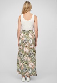 Hvit tanktopp med et grønt blomstermønstret maxiskjørt som har rosa og grå blader. Skjørtet har elastisk midje og er gulvlengde.