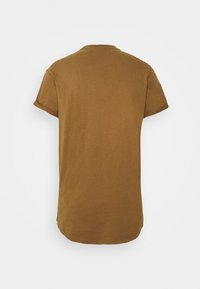 T-shirt in cotone marrone con maniche corte arrotolate, scollatura rotonda e orlo arrotondato sul retro. Design semplice, senza motivi o accenti.