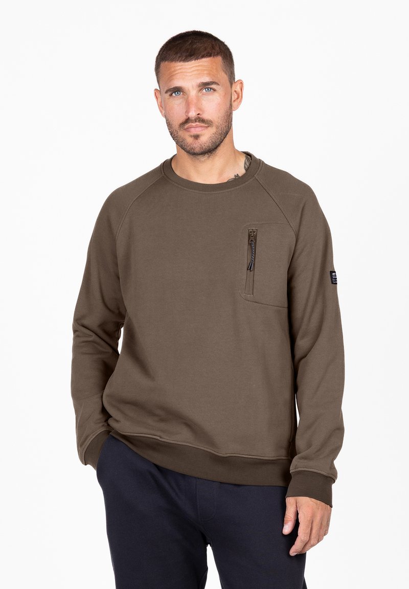 Sudadera verde oliva con mangas raglán, cuello redondo, bolsillo con cremallera en el pecho y puños acanalados. Tejido suave con un corte holgado.